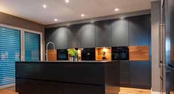 Moderne Treppe mit integrierter LED-Beleuchtung, große Fliesen, Pflanze und Fenster, gestaltet von Brumberg.